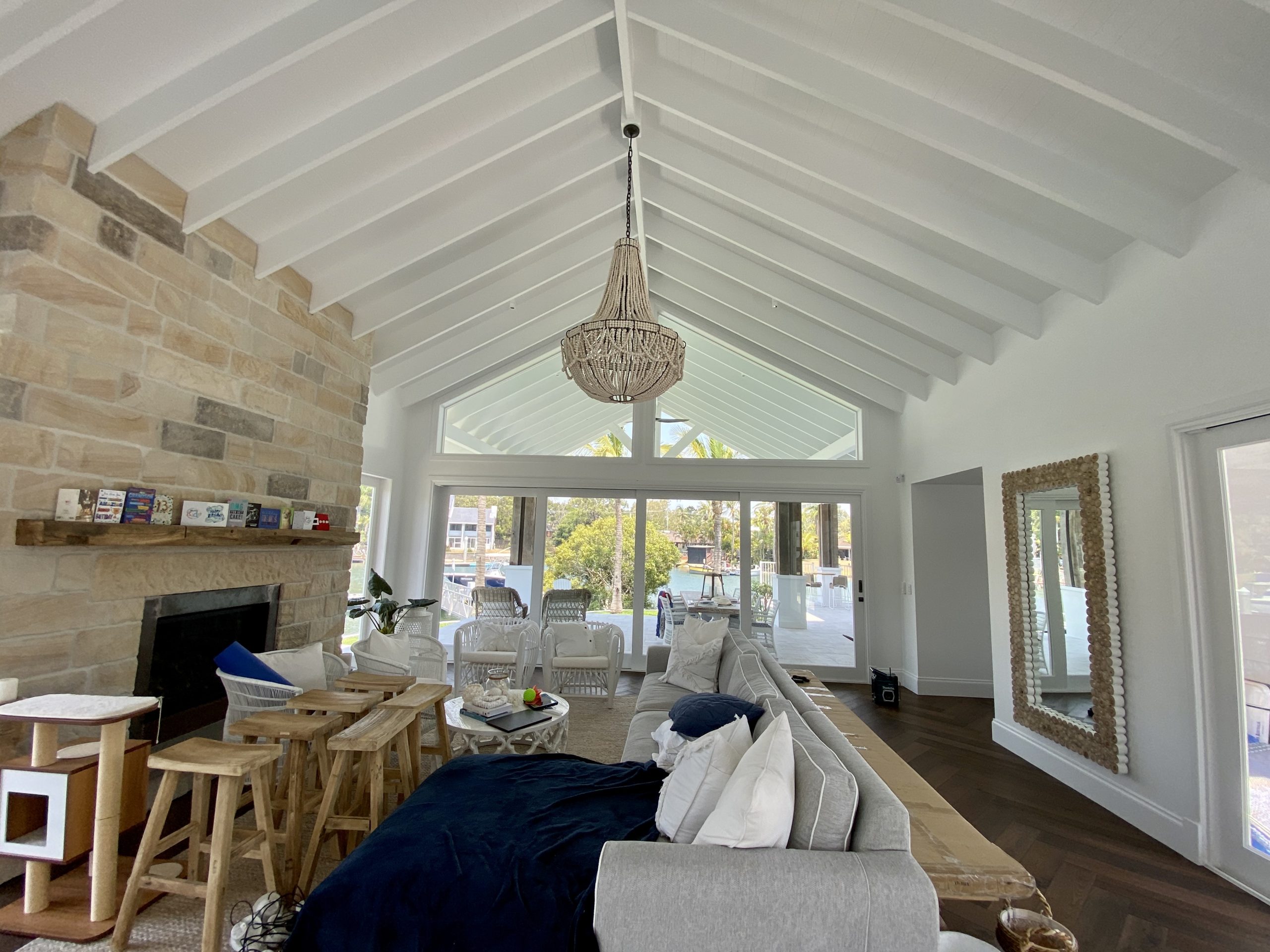 White vaulted ceiling and walls in a living room with a stone fireplace