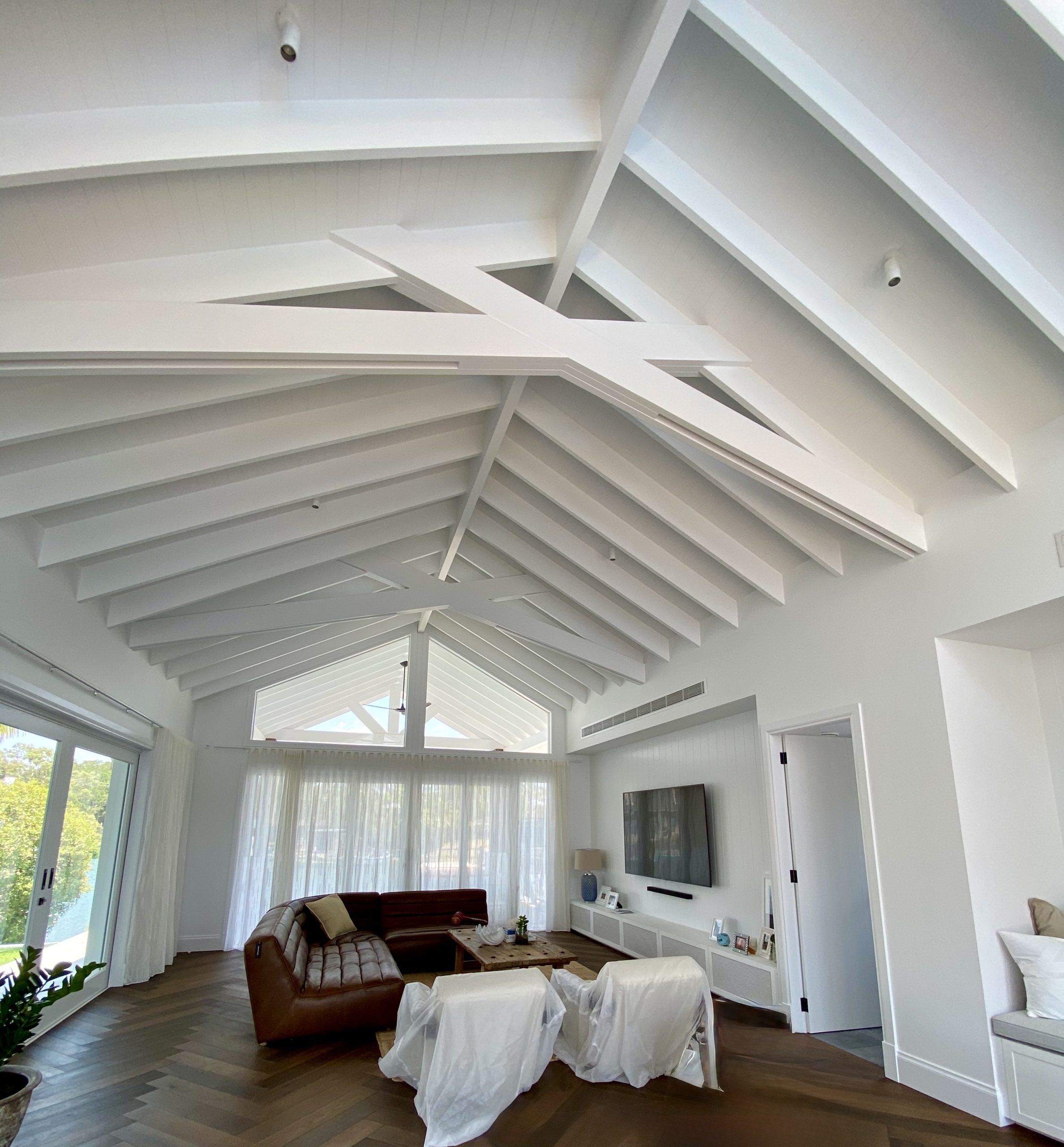 White vaulted ceiling and exposed beams above a living room
